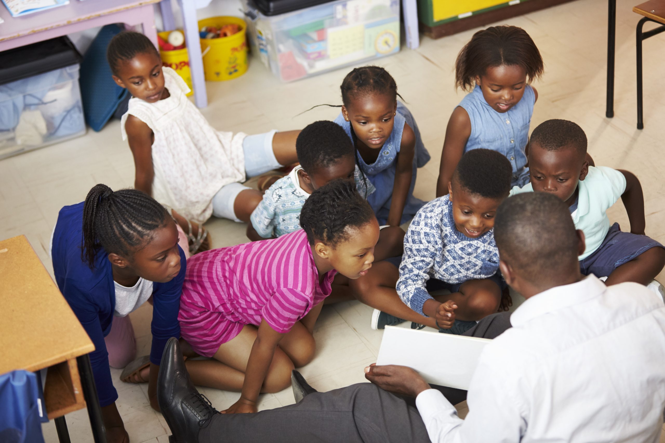 Teacher reading kids a book in an elementary school lesson